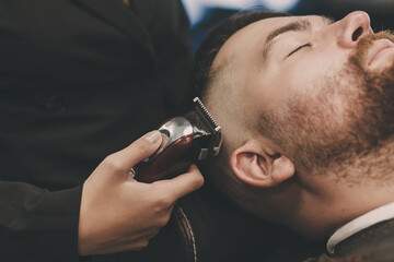 Hairdresser cutting hair of male