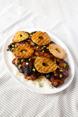 Homemade Hawaiian Huli Huli Chicken on a white plate on cloth, side view.