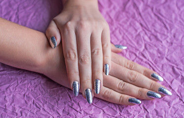 Close up photo of manicure 80s - 90s. Beauty trends, retro sparkle nails, silver color 