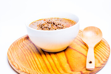 Bowl of lentils on a wooden tray and white background
