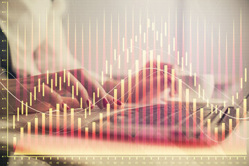 Multi exposure of woman hands typing on computer and financial graph hologram drawing. Stock market...