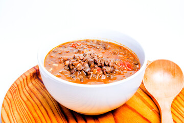 Bowl of lentils on a wooden tray and white background