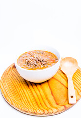 Bowl of lentils on a wooden tray and white background