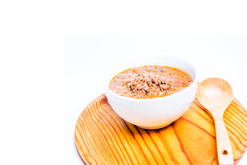 Bowl of lentils on a wooden tray and white background
