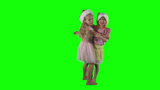 Two best friends girls play and simper in front of camera. Chroma key