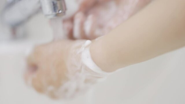 石鹸で手を洗う女性