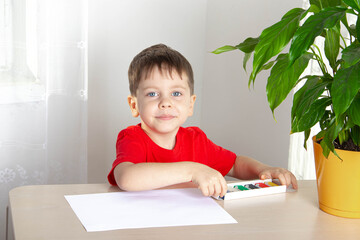 The boy at the table sculpts from plasticine . Children's leisure. We're sitting at home. Self-isolation. The coronavirus. Children's Hobbies.