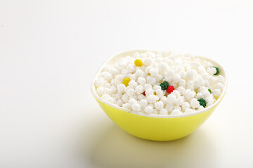 Indian festival makar sankranti concept : Tilgul in bowl with copy space on white background