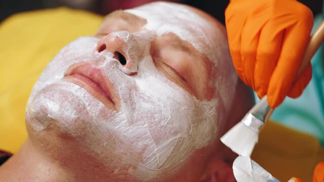 cosmetology, cosmetic procedures for men. close-up. man is lying on couch and getting facial skin care procedure, at beauty clinic. Skin care, dermatology treatment.