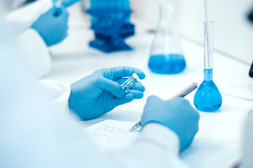 Fototapeta premium rear view. scientist recording the results of investigations in a laboratory journal .