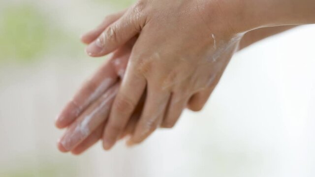 ハンドクリームをつける女性の手