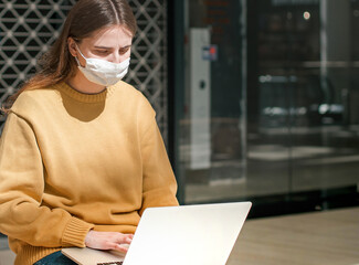 Fototapeta na wymiar young woman works on a laptop during a pandemic