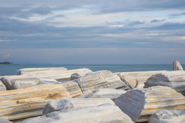 Landscape, view to the blue sea and sky by sunset colors over the old marble stones in the historical, ancient city side Antalya. Selective Focus.