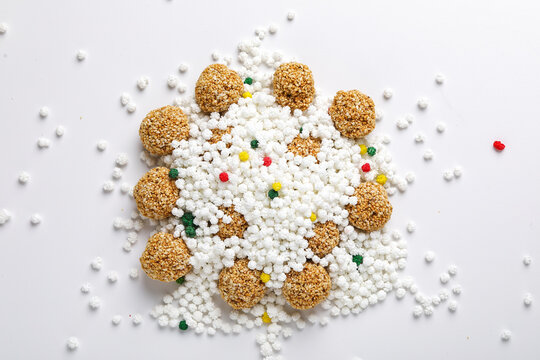 Indian festival makar sankranti concept : tilgul and sesame seed ball or laddo on white background