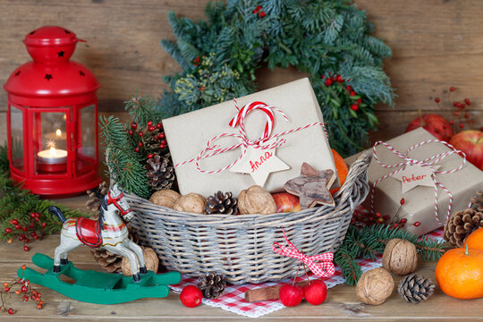 Weihnachtsdekoration mit Geschenken im Korb, Äpfeln, Walnüssen und Zapfen