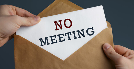 Male hands holding craft envelope with text NO MEETING on blue background