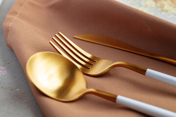 Set of golden cutlery on napkin close up
