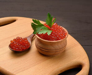 fresh grainy red chum salmon caviar in a wooden plate, delicious and healthy food