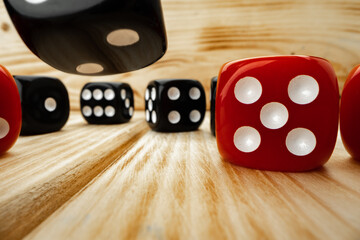 Red and black dice cubes on wooden background