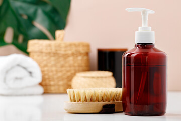 Fototapeta na wymiar Liquid soap container and massage brush in bathroom