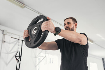 man caucasian handsome and big muscle in sportswear. Young man holding weights during an exercise class in a gym. Healthy sports lifestyle, Fitness concept. with copy space for your text.