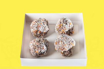 Dried fruit cakes in coconut sprinkle on a light background. Home delivery. Festive concept. Quarantine.