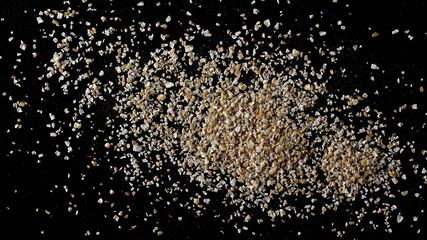 Oat bran pile isolated on black background, top view