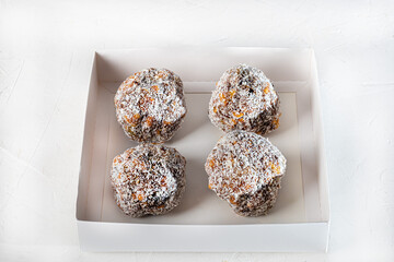 Dried fruit cakes in coconut sprinkle on a light background. Home delivery. Festive concept. Quarantine.