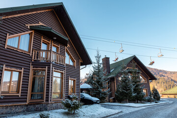Snow-covered houses in the mountains. Cottages at a ski resort. Winter street. Winter Ukrainian Carpathians.