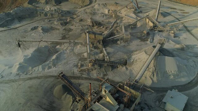 Aerial flight above epic industrial landscape. Many steel conveyors mobile concrete batching plant station. Alien colonization new planet ore mining futuristic factory. Mountains of gray dust rubble