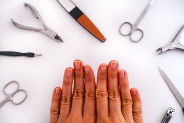 Woman's hands with uncoated manicure and home manicure tools.