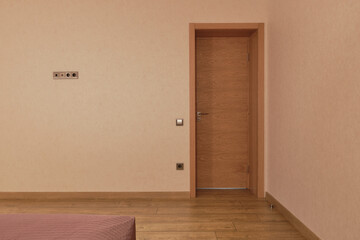 Wooden door in bedroom room interior. Laminate on the floor. Real Estate objects. Concept of hotel or apartment rent.