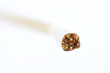 The tip of a cigarette standing on a white background. View from above. Tobacco smoking and other bad habits. Free space for inscription. Macro.