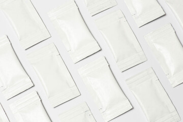Close-up composition of white sachets on a white background.