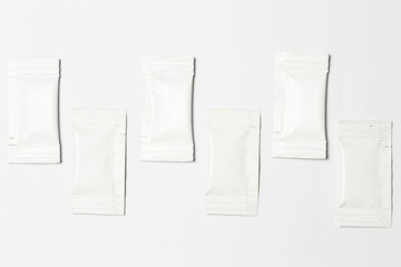 Close-up composition of white sachets on a white background.