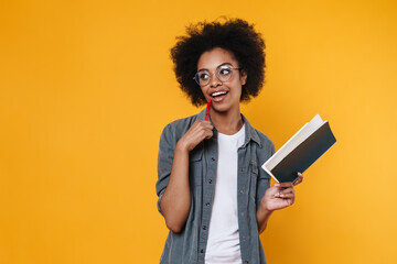 Joyful african american girl in eyeglasses posing with exercise book