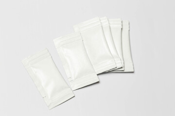 Close-up composition of white sachets on a white background.