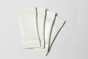 Close-up composition of white sachets on a white background.