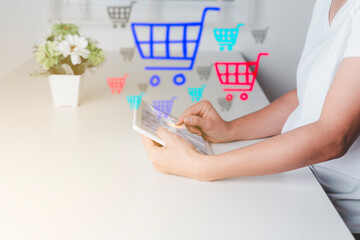 An Asian woman is using a tablet to make an online purchase.