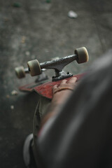 Skate rojo en la mano.