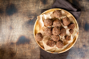 Chocolate coconuts. Chocolate balls with coconut. Chocolate candies or cookies with coconut, cinnamon and powdered sugar
