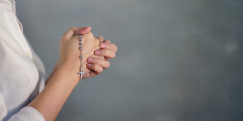 cross rosary in woman hands praying for god blessing