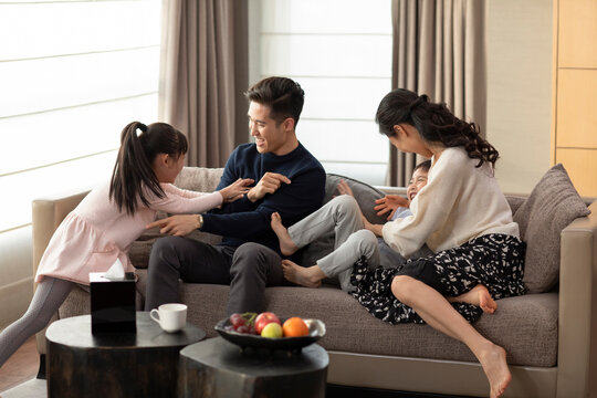 Happy young family having fun in living room