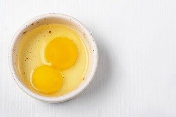 two egg yolks in a bowl on a light background. Diet food concept

