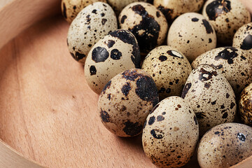 top view of quail eggs in round wooden box.Monochrome in food background