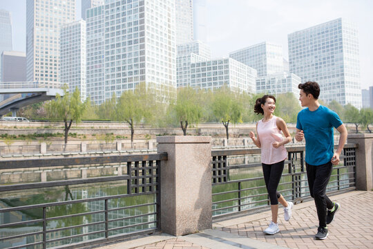 Happy young couple running in park