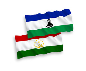 National vector fabric wave flags of Tajikistan and Lesotho isolated on white background. 1 to 2 proportion.