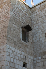 Window with bars on the wall of the Church of Nativity building in the central square in the city of Bethlehem in the Palestinian Authority, Israel