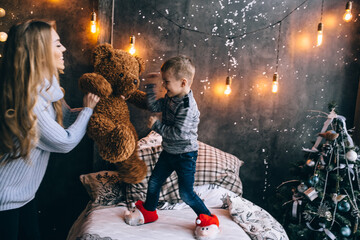 boy and mother playing with teddy bear