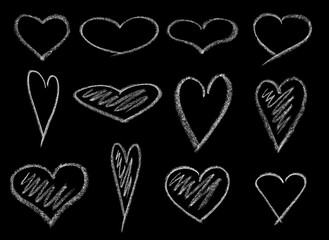 Set of beautiful hearts, hand-drawn with white chalk on a black chalkboard for design. Isolated on black background